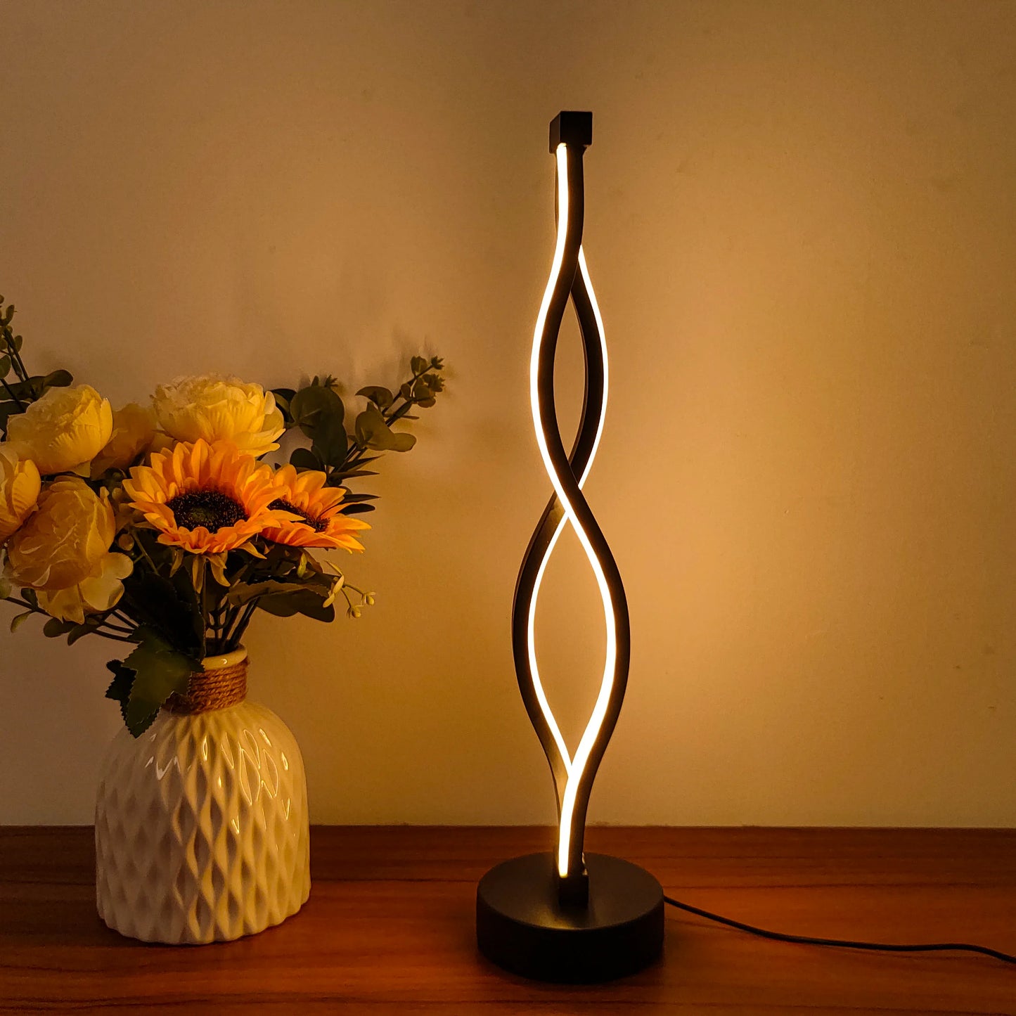 Lampe de bureau design LED torsadée avec décor floral, éclairage chaleureux pour ambiance intérieure cosy.