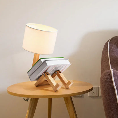 Lampe de bureau en bois posée sur une table ronde, lumière douce idéale pour décoration intérieure moderne.