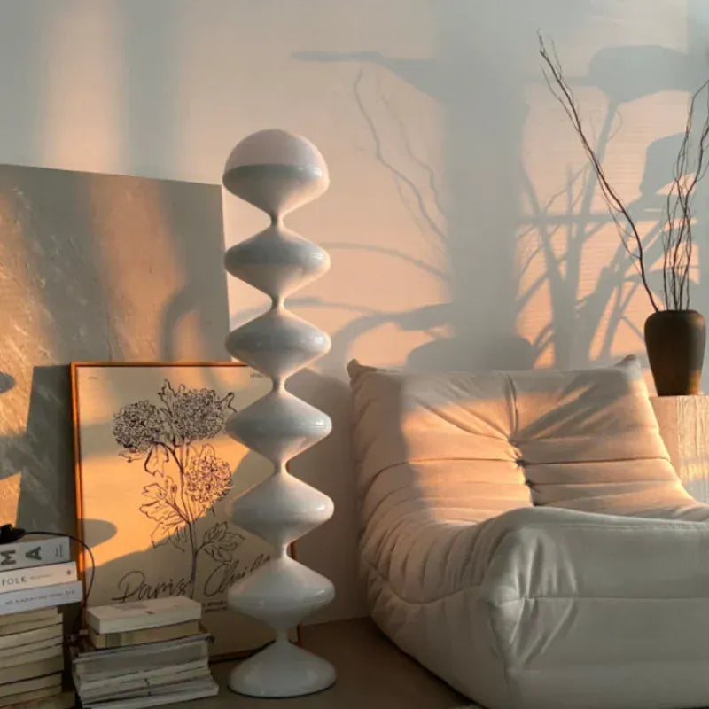 Lampe sur pied design sculpturale dans un intérieur cosy, ambiance chaleureuse et moderne.