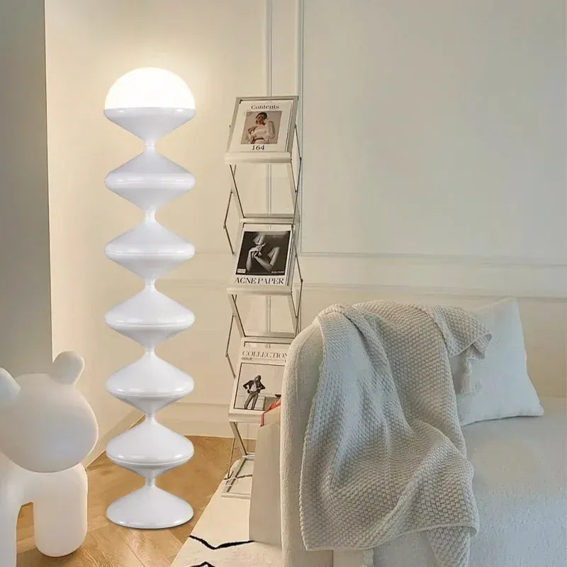 Lampe sur pied design blanche placée dans une chambre moderne, lumière douce et élégante.
