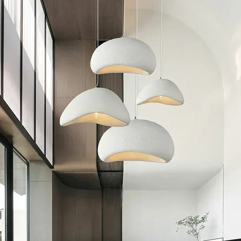 Suspensions design blanches installées en hauteur, luminaire moderne pour cuisine ou salon.