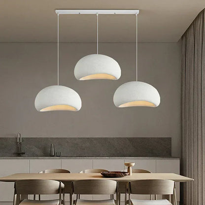 Suspension cuisine moderne avec trois dômes blancs, éclairage décoratif pour cuisine bois clair.
