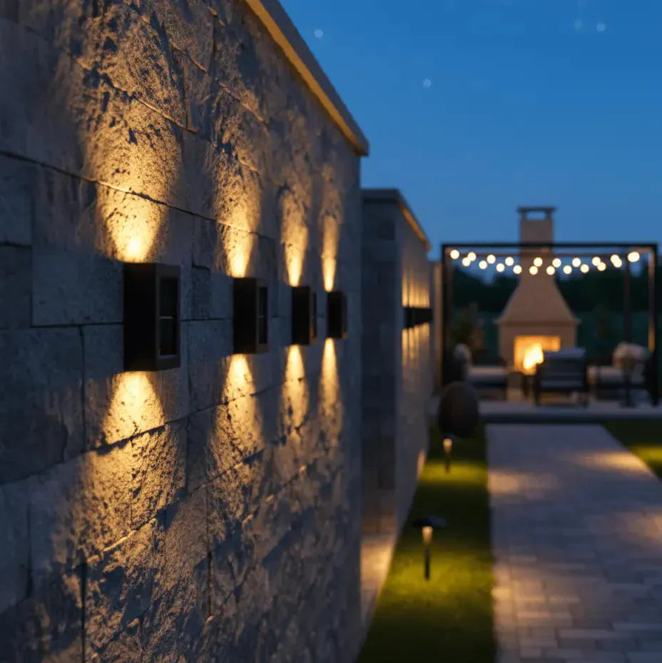 Luminaires extérieurs alignés sur façade en pierre, éclairage décoratif pour jardin et allée