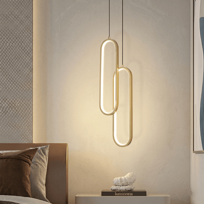 Suspension lumineuse dorée avec forme ovale, éclairage décoratif haut de gamme pour intérieur moderne.