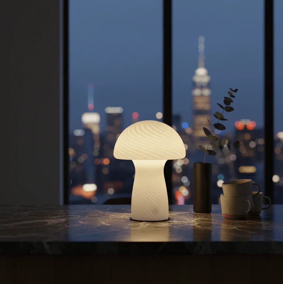 Lampe champignon en verre éclairée dans un salon avec vue nocturne, ambiance chaleureuse et moderne.