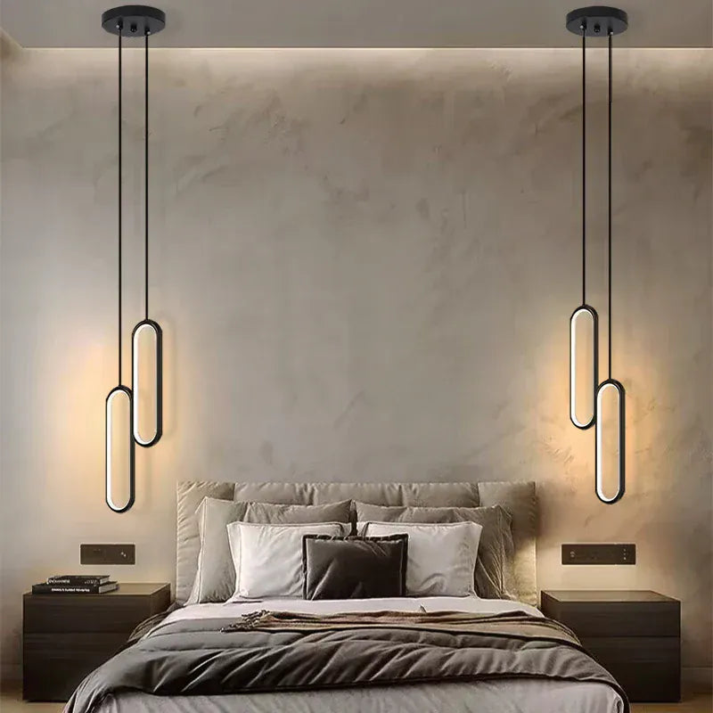 Suspensions lumineuses modernes installées de part et d’autre d’un lit, éclairage décoratif pour chambre élégante.