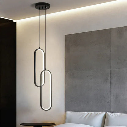 Suspension lumineuse noire à double anneau, luminaire design pour salon ou chambre contemporaine.